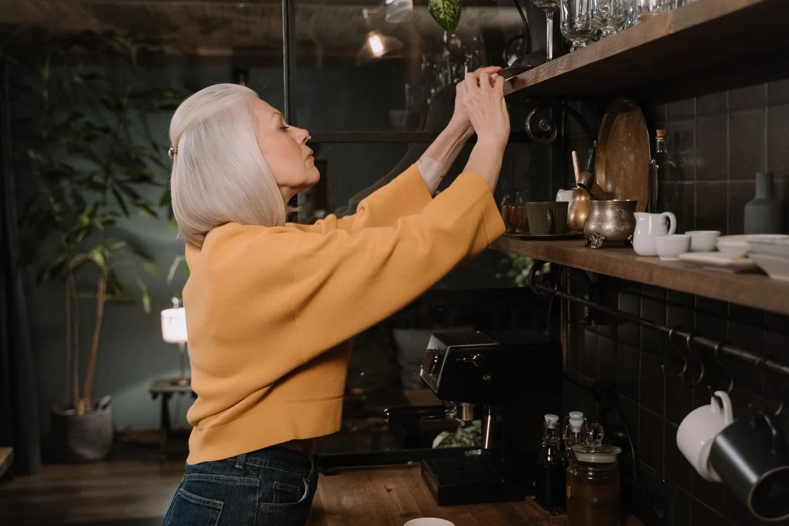 Photo of Maya reaching to organize a kitchen shelf