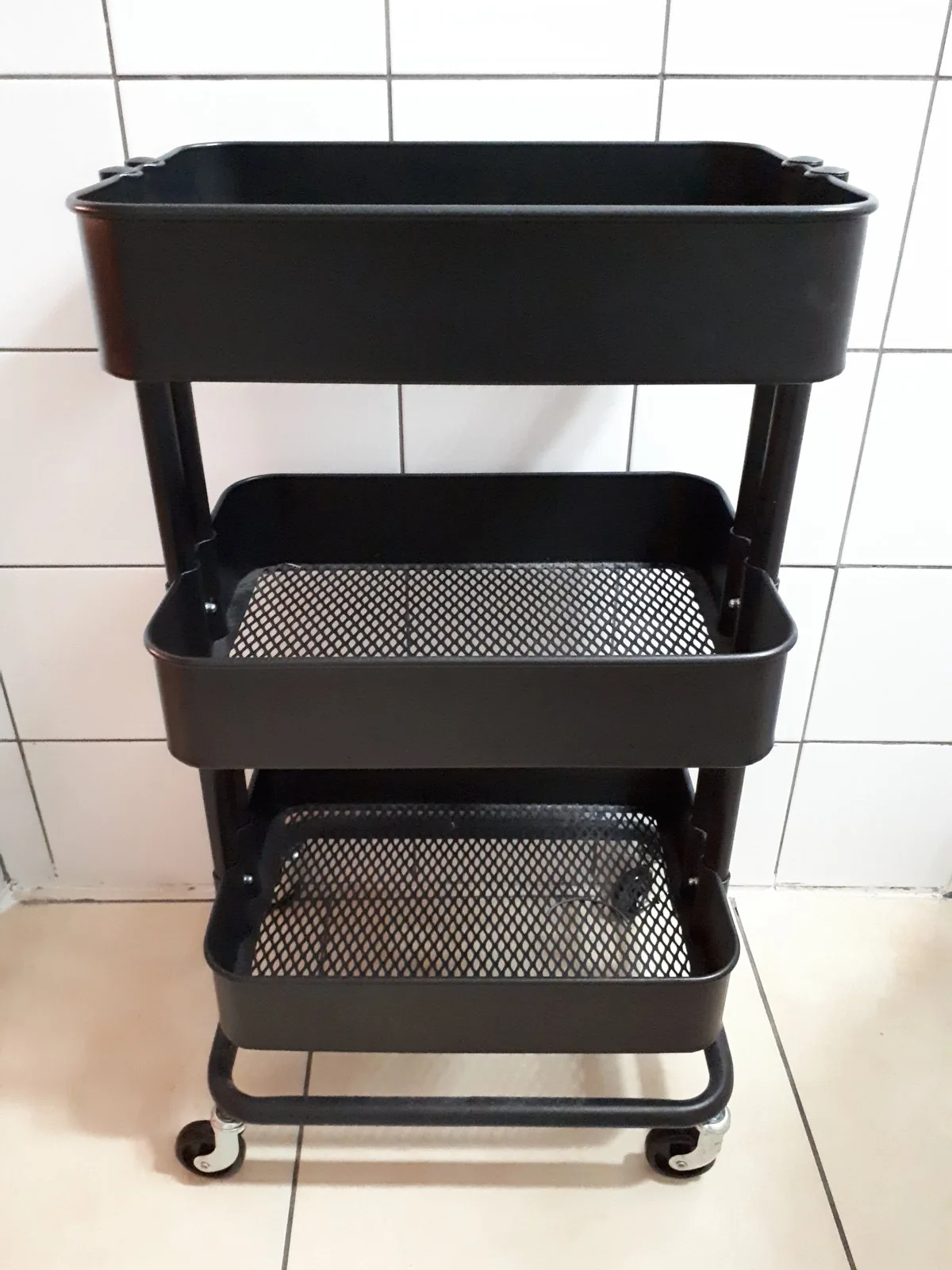 Photo of a black three-tier metal rolling utility cart