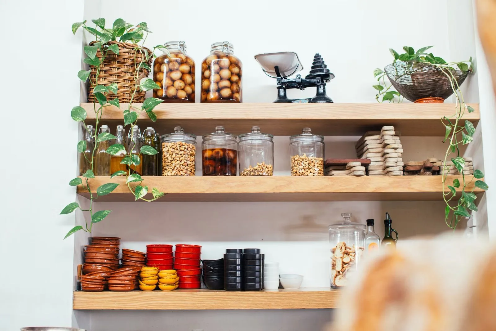 Photo of no-drill open wall shelves with jars and plants in a small kitchen